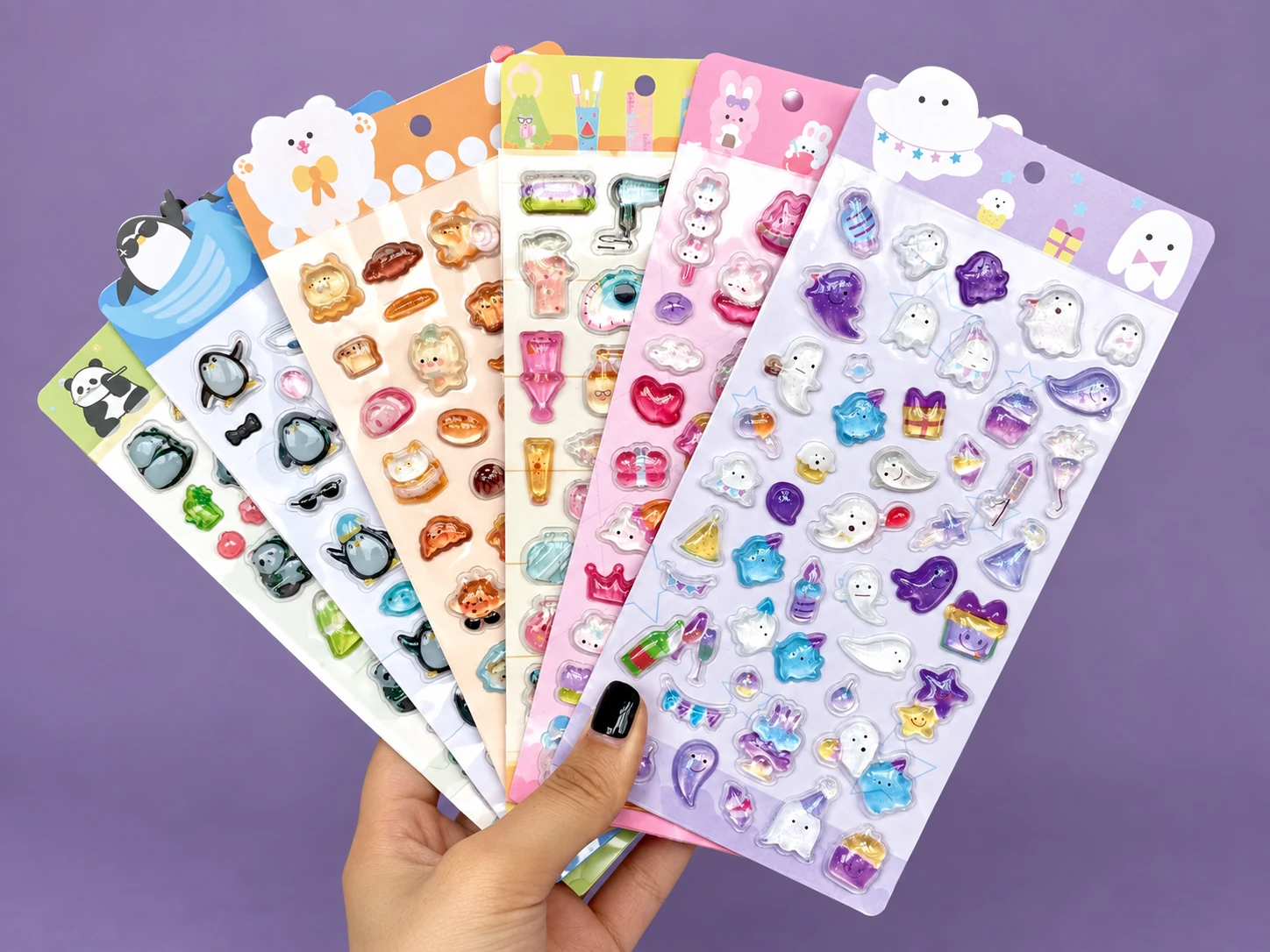Hand holding six colorful dimensional puffy sticker sheets in a fan arrangement