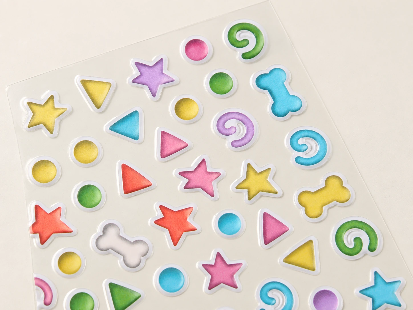 Close-up of epoxy dome stickers showing clear raised resin edges and glossy printed surfaces.