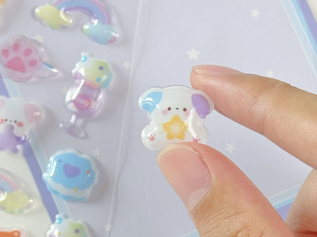 Small pastel animal bubble sticker held between two fingers