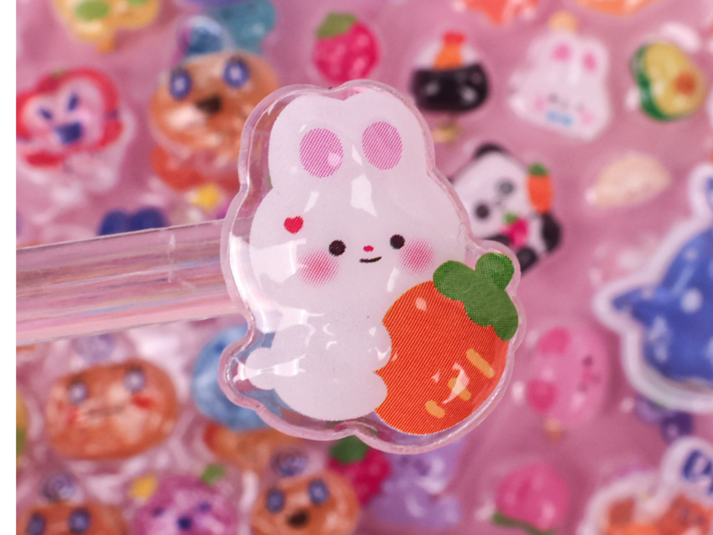 Close-up of a pink rabbit bubble sticker holding a strawberry