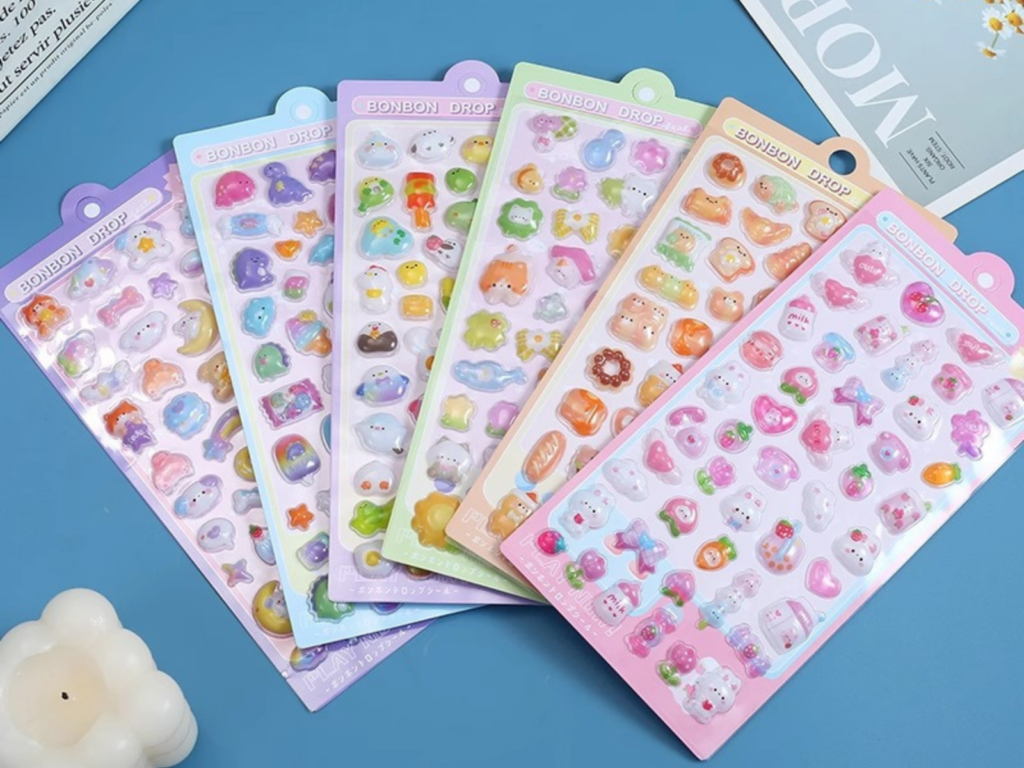 Themed 3D bubble sticker sheets fanned out on a blue surface