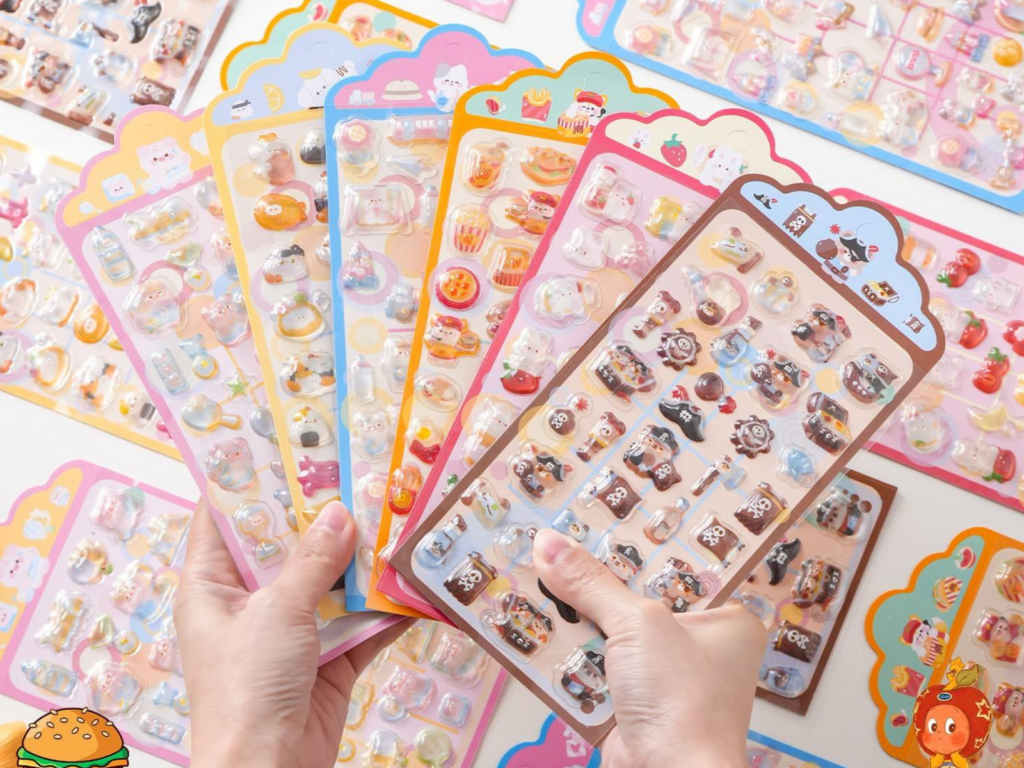 Hands holding a selection of colorful 3D bubble sticker sheets