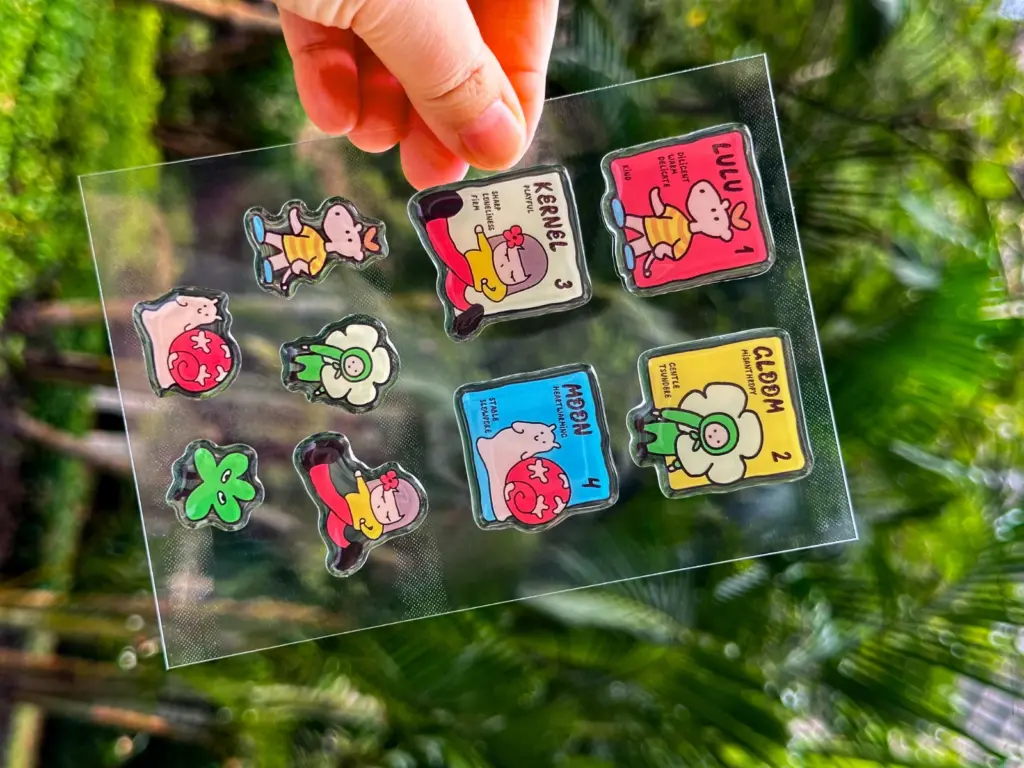 A clear puffy sticker sheet showing colored square designs alongside shapes with transparent borders.