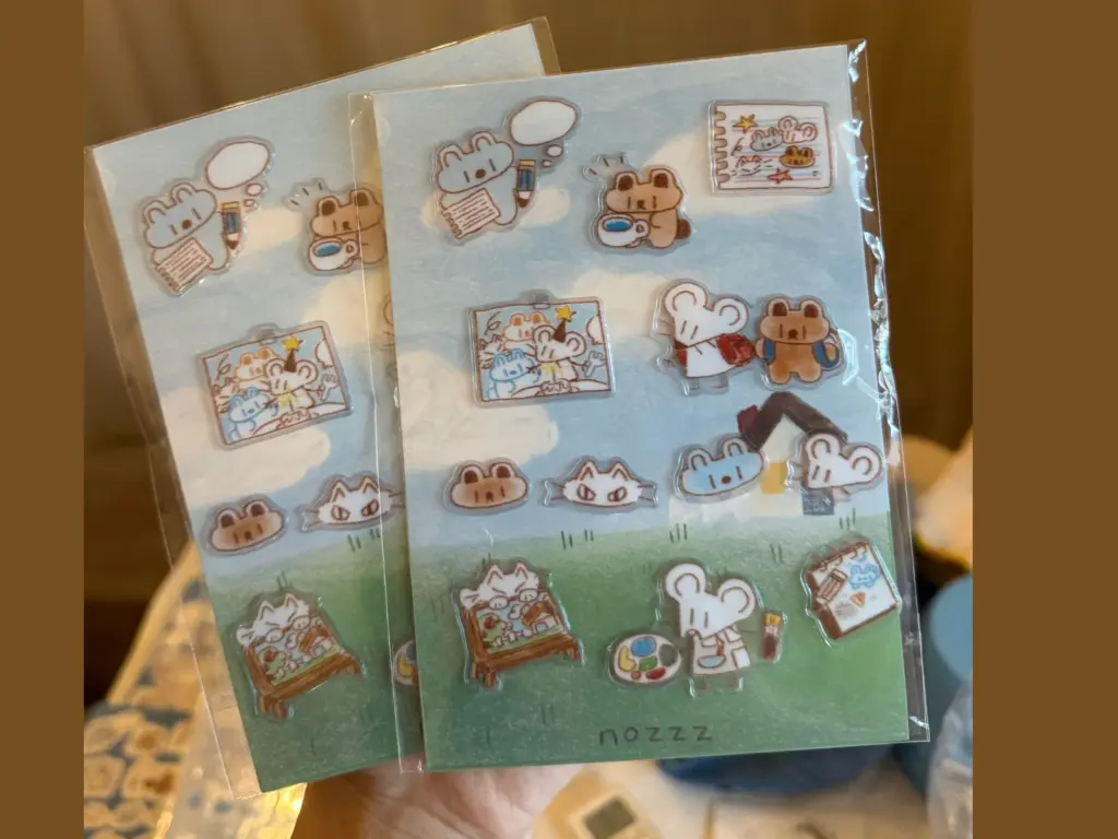 Two clear puffy sticker sheets in clear bags with illustrated backing cards visible behind the stickers.