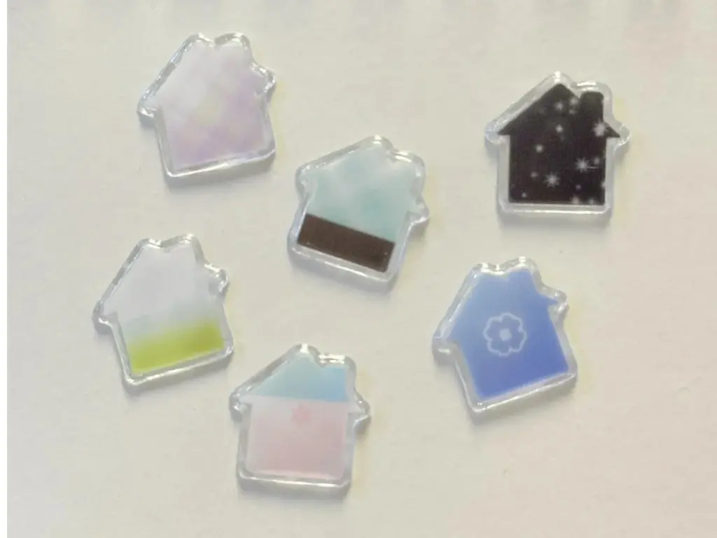 Five house-shaped clear puffy stickers arranged on a light surface, showing their transparent borders.