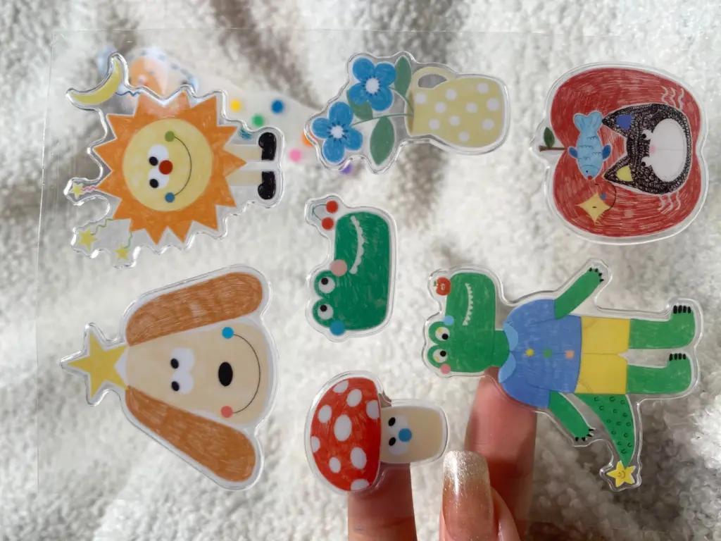 Hand-held clear puffy sticker sheet showing several printed shapes separated by clear spaces.