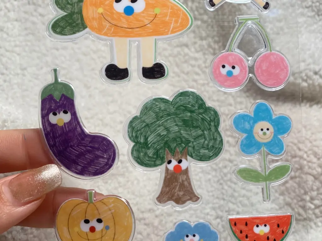 Close-up of colorful printed designs and transparent spaces on a clear puffy sticker sheet.