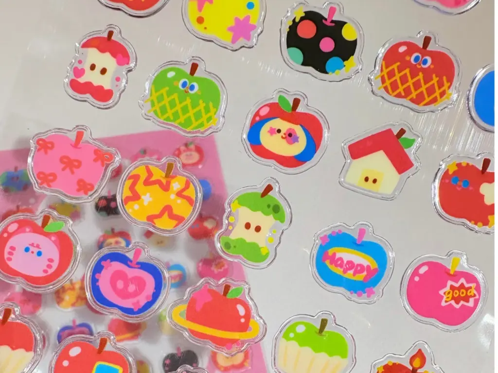 Clear puffy sticker sheet with multiple printed designs in the same apple-shaped outline.