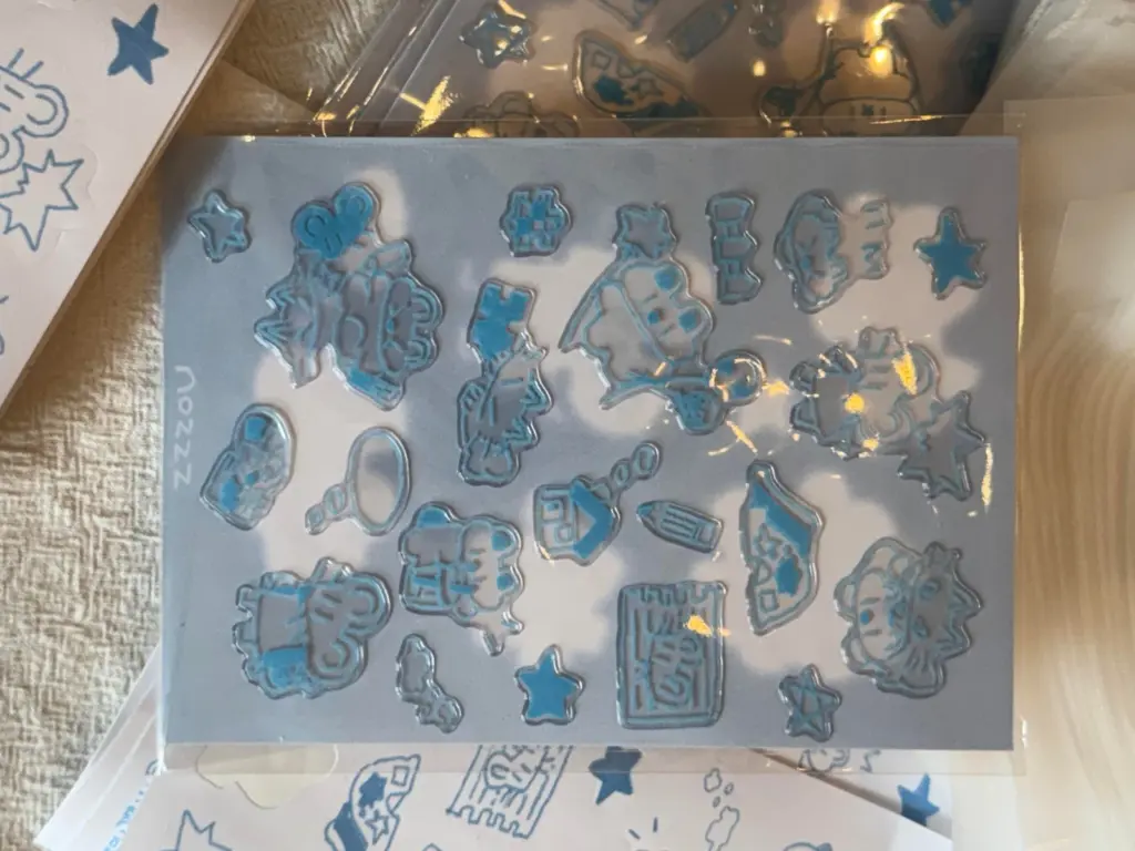 Clear puffy sticker sheet with blue printed outlines and see-through areas within the designs.